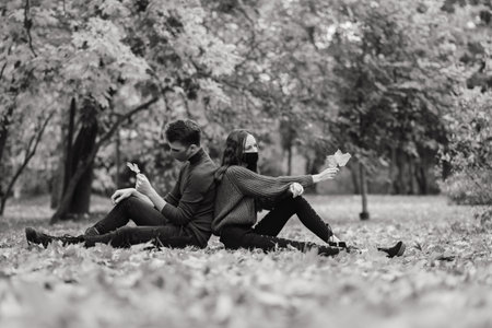 Young couple wearing masks together in forest, parkの写真素材