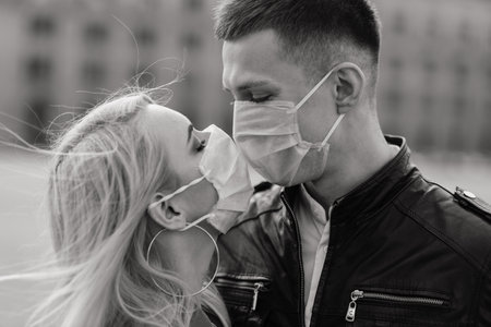 Young couple in love in protective medical mask on face outdoor at street. Covid protection conception.の写真素材