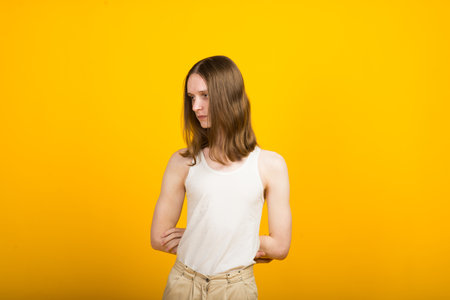 Androgynous beautiful young man. Model tests in yellow backgroundの写真素材