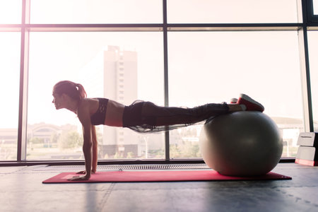 Shot of fitness woman on exercise mat. Female athlete lying on her back doing gym workoutの写真素材