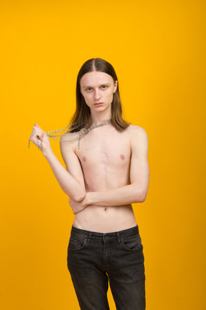 Androgynous beautiful young man. Model tests in yellow backgroundの写真素材