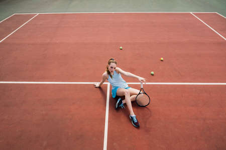Sexy girl tennis player in white dress and heels holding tennis racket on the court. Young woman is playing tennis, sportの写真素材