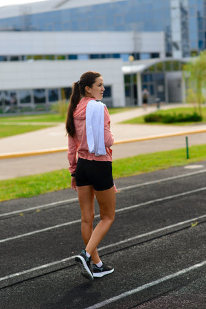 Outdoor shot of young woman athlete running on racetrack. Professional sportswoman during running...