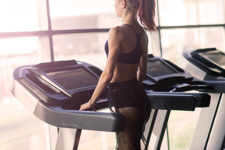 Young woman exercise fitness and workout while run on track in a sport clubの写真素材