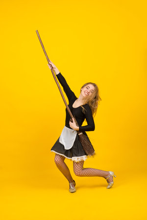 Sexy maid on broomstick in studio, witches, evil spirits.の写真素材