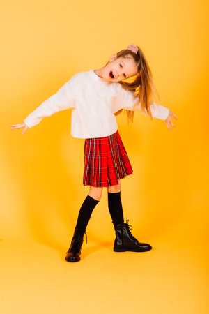 Portrait of beautiful, joyful and confident girl isolated on yellowの写真素材