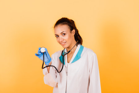 Portrait of beautiful African American doctor or nurse isolated on yellow backgroundの写真素材