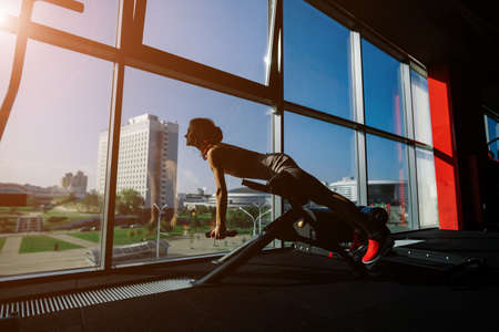 Athletic girl in sportswear performs exercises with a barbell, dumbbells. Fitness, workout, healthy lifestyleの写真素材