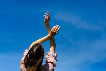 Happiness bliss freedom concept. Woman happy smiling joyful with arms up dancing in summer during holidays travel. Beautiful young cheerful modelの写真素材