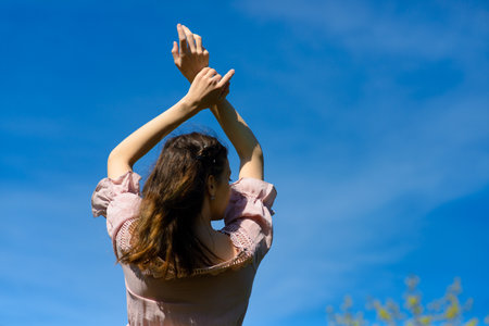 Happiness bliss freedom concept. Woman happy smiling joyful with arms up dancing in summer during holidays travel. Beautiful young cheerful modelの写真素材