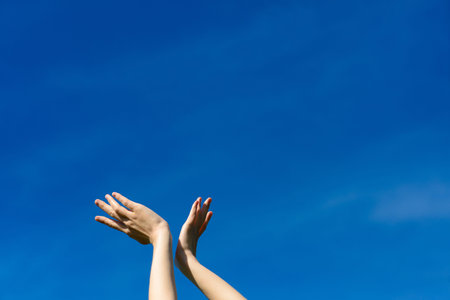 I wish we could touch the sky, female stretching hands to blue sky. Freedom and spring conceptの写真素材