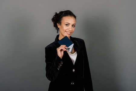 An isolated shot of a happy black businesswoman in studio, notebook, smartphoneの写真素材