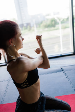 A young and beautiful female trains with a barbell in gym. Posing with elements for training