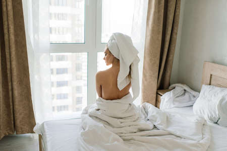 Beautiful young healthy woman relaxing in a robe, hotes, room and spa salonの写真素材