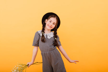 Funny child girl smiling with bouquet of flowers on coloured background