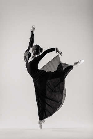 Portrait of Sensual professional caucasian   dancer in body suit and pointes shoes posing on floor on white.の写真素材