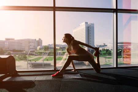 Athletic girl in sportswear performs exercises with a barbell, dumbbells. Fitness, workout, healthy lifestyleの写真素材