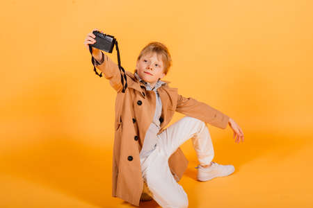 Child boy red head photographer with retro photocamera in a studioの写真素材