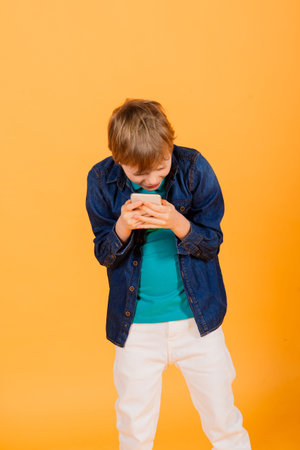 The little boy phones on yellow background