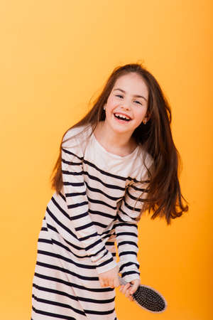 Little girl singing using hairbrush as microphoneの写真素材