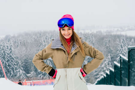 Minsk, Belarus - 01.22.2021. Young sporty smiling woman in winter with snowboard, glassesのeditorial素材