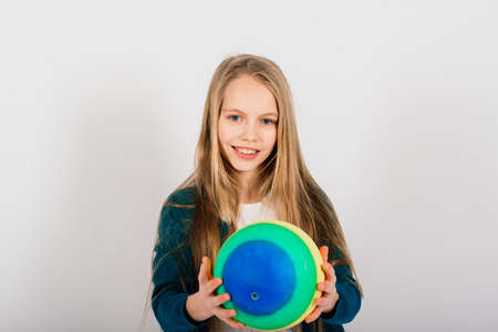 Beautiful girl holding coloured bright ball isolated on white, studioの写真素材