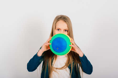 Beautiful girl holding coloured bright ball isolated on white, studioの写真素材