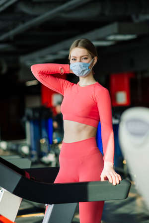 Woman wearing face mask exercise workout in gym during  virus pandermicの写真素材
