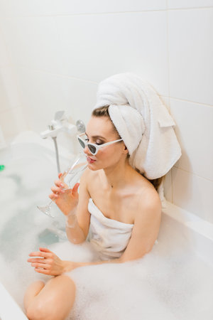 Portrait of attractive woman in bathroom, towel on head