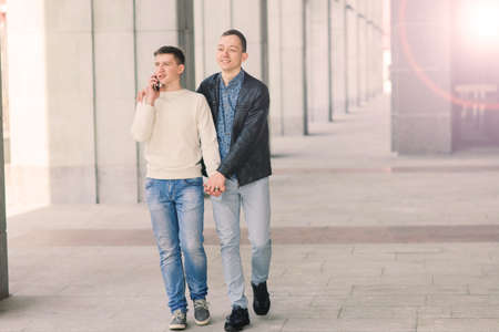 Young gay couple smiling happy and hugging at city.の写真素材