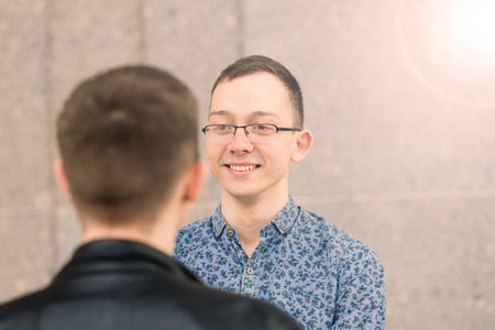 Young gay couple smiling happy and hugging at city.