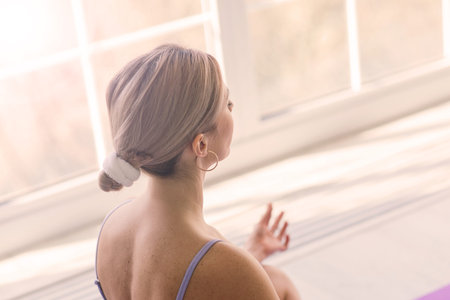 Young attractive smiling woman practicing yoga, working out, wearing sportswear, bra, home training