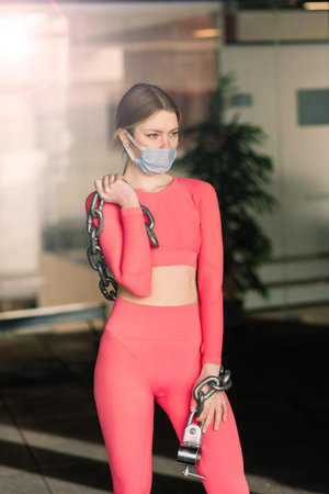 Woman wearing face mask exercise workout in gym during corona virus pandermic, covid
