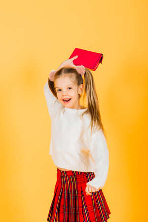 Teenager girl over yellow wall holding walletの写真素材