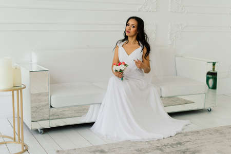 Happy beautiful bride with her veil smiling and excited in an interior, wedding morningの写真素材