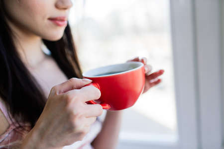 Woman near window at home. Dream and relaxingの写真素材