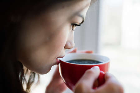 Woman near window at home. Dream and relaxingの写真素材