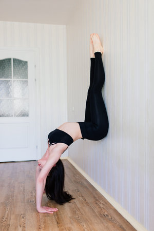 Staying fit and healthy. Beautiful young woman in sports clothing doing yoga while relaxing, home