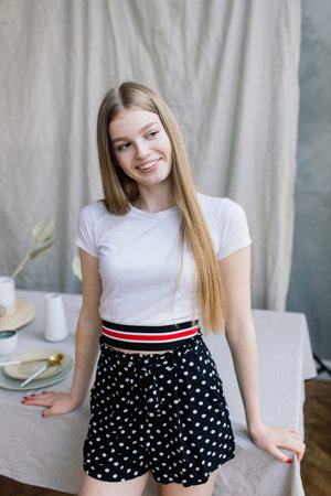 Young attractive woman relaxing on white sofa at the window at homeの写真素材