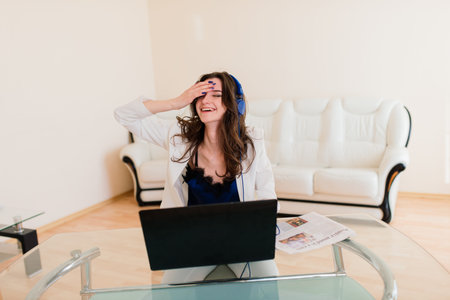 Happy young beautiful woman working and using laptop, indoors