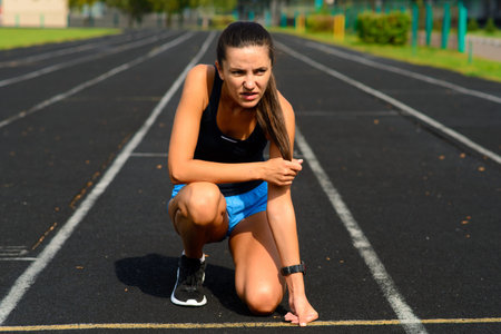 Outdoor shot of young woman athlete running on racetrack. Sportswoman during running training.の写真素材