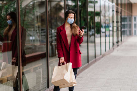 Close up portrait of caucasian female wearing a medical mask and standing in street and of a cafeの写真素材