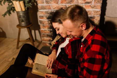 Young guy kissing lovely girlfriend feeling happiness while celebrating winter holidays togetherの写真素材
