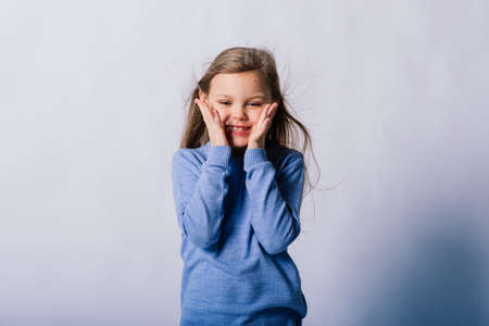 Portrait of beautiful little girl happy smiling on a studio. Isolated white backgroundの写真素材