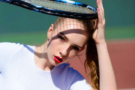 Female player in white dress and heels holding tennis racket. Young woman is playing tennis, sportの写真素材