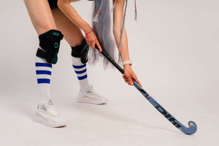 Minsk, Belarus - 06.27.2021. Beautiful young woman holding a floorball hockey stick against white backgroundのeditorial素材