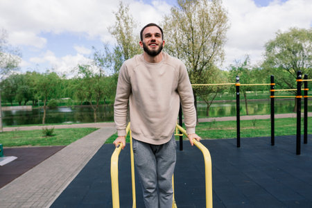 Caucasian sportsman pulling up wide grip hand on crossbar during street workout.の写真素材