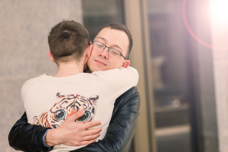 Young gay couple smiling happy and hugging at city.