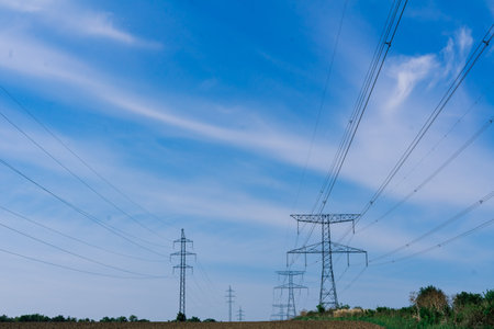 Electric power transmission lines at sky background, an autumn field