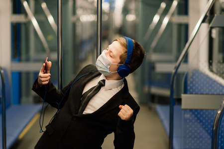 A boy in medical mask is sad at the train window, a child is traveling alone.の写真素材